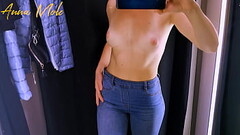 A girl in tight pants caresses small breasts in a fitting room. Thumb