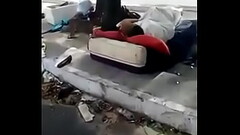 Morador de rua trepando no meio da rua Thumb