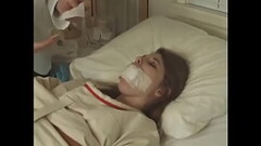 Pretty brunette in Straitjacket taped mouth tied to bed hospital Thumb